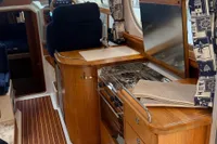 Interior of 2001 Nimbus 345 Coupe boat with wooden cabinetry and compact kitchen area.