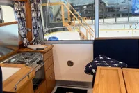 Interior of 2001 Nimbus 345 Coupe with kitchen and seating area, featuring nautical decor.