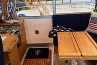 Interior of 2001 Nimbus 345 Coupe with wooden table, kitchenette, and star-themed decor.