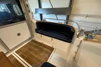 Interior of 2001 Nimbus 345 Coupe with wooden flooring and navy seating.