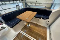 Interior of 2001 Nimbus 345 Coupe with wooden table and navy seating.