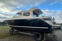 Nimbus 345 Coupe 2001 boat on trailer under cloudy sky.