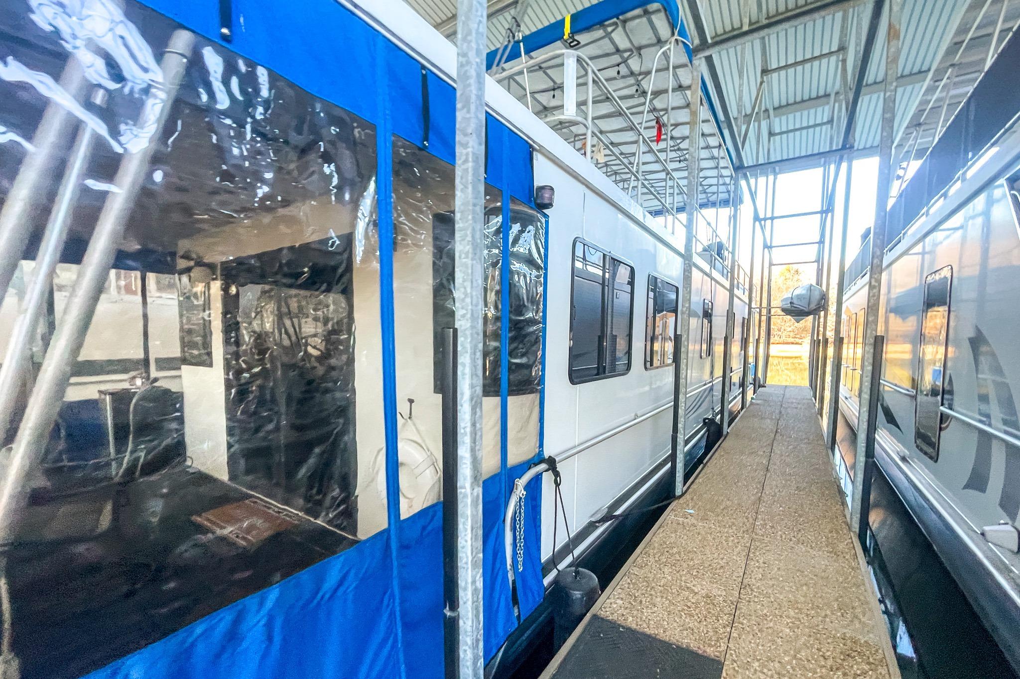 1996 Lakeview 66 x 16 Widebody Houseboat docked in a covered marina.