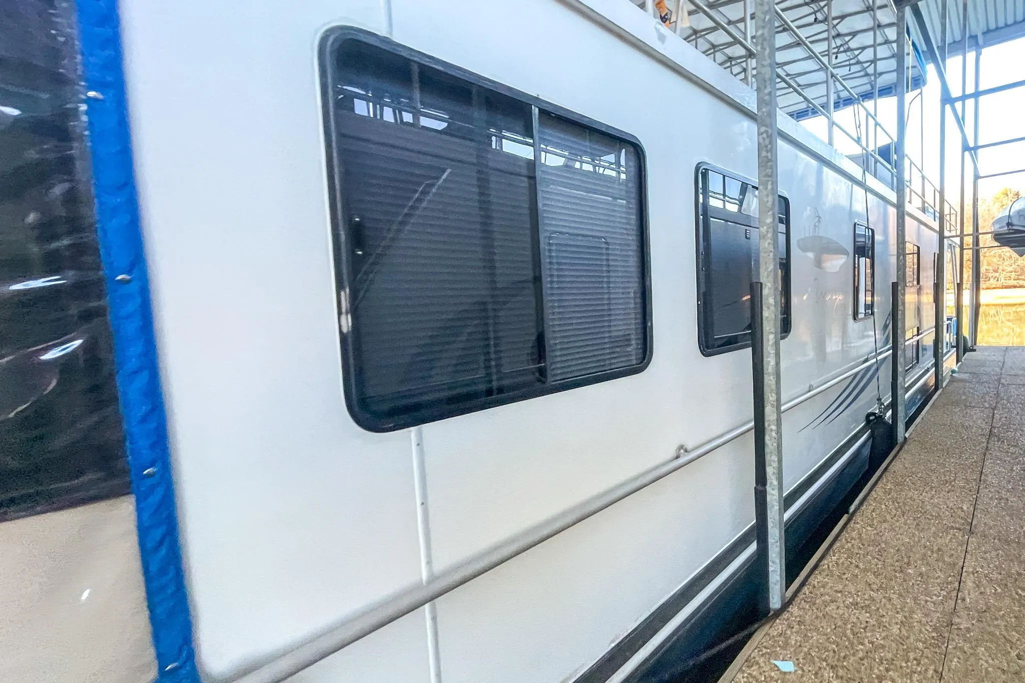 1996 Lakeview 66 x 16 Widebody Houseboat docked in a marina.