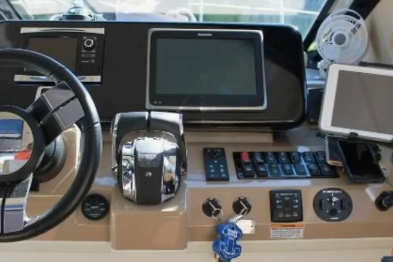  Yacht Photos Pics Control panel of a 2017 Carver C37 yacht with steering wheel and navigation screens.