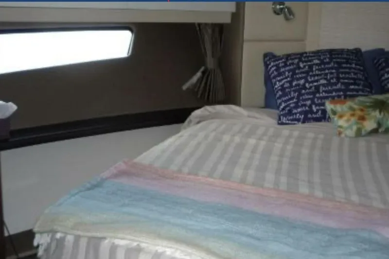  Yacht Photos Pics Cozy bedroom interior of 2017 Carver C37 yacht with striped bedding and decorative pillows.