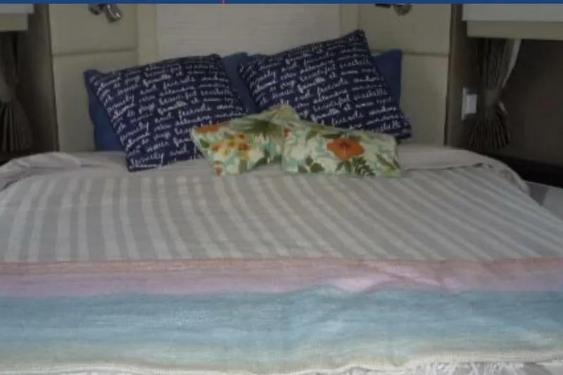  Yacht Photos Pics Cozy bed with striped bedding and decorative pillows in a 2017 Carver C37.