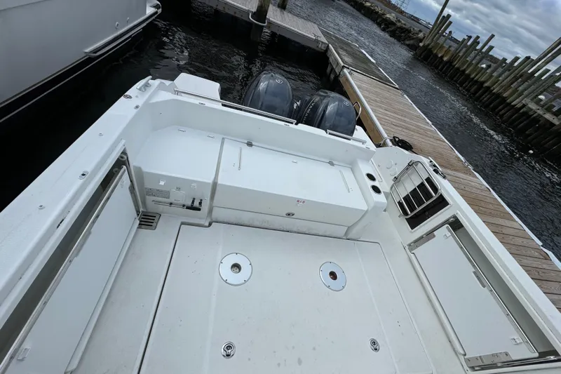  Yacht Photos Pics 2023 Jeanneau Leader 9.0 CC boat docked, showcasing spacious deck and dual outboard engines.