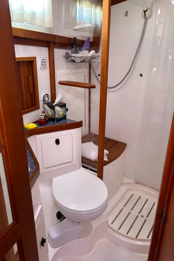 Bravo Yacht Photos Pics 2005 Sabre 42 Hardtop Express bathroom with shower, toilet, and wooden accents.