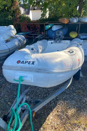 Bravo Yacht Photos Pics Inflatable Apex boat on trailer, surrounded by other boats and equipment.