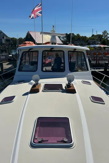 Bravo Yacht Photos Pics 2005 Sabre 42 Hardtop Express yacht docked, featuring a sleek deck and British flag.