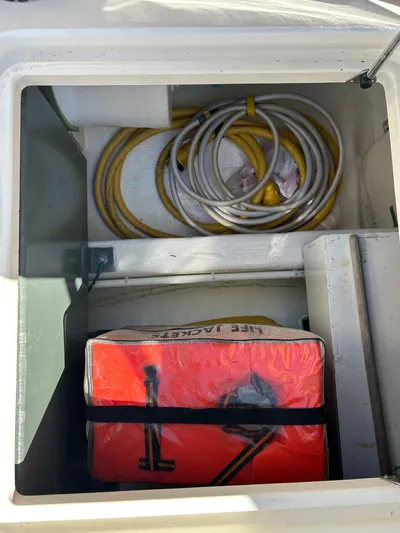 Bravo Yacht Photos Pics Storage compartment on a 2005 Sabre 42 Hardtop Express with coiled cables and a red bag.
