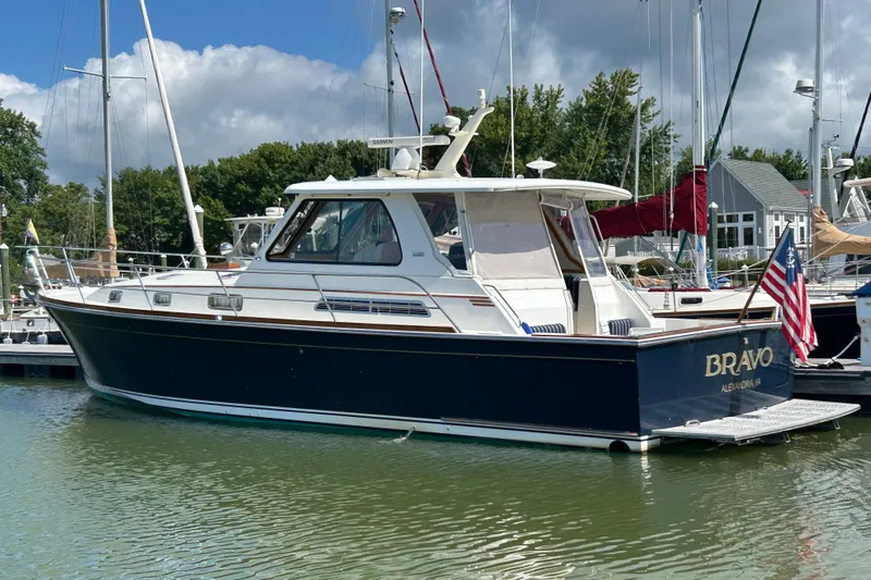 Bravo Yacht Photos Pics 2005 Sabre 42 Hardtop Express yacht docked in a marina, featuring a sleek design and American flag.