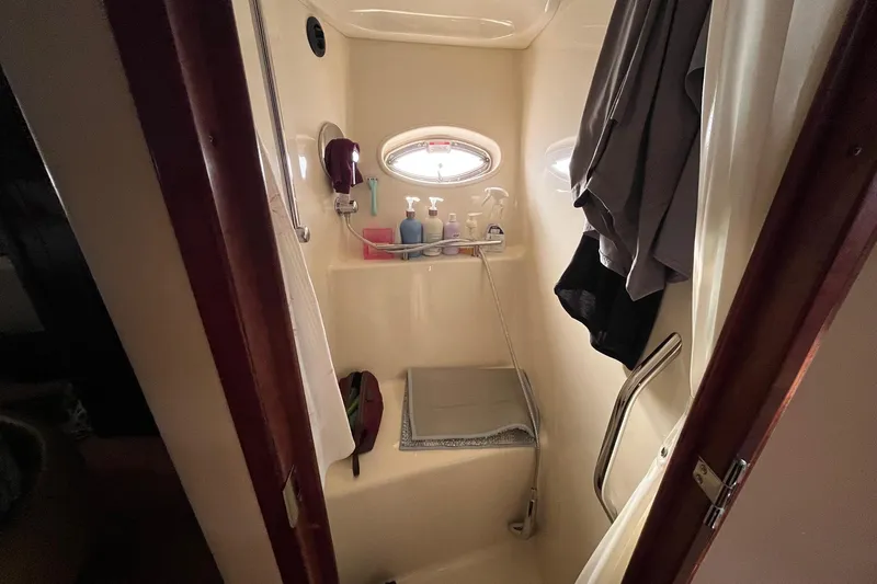 Sonship Yacht Photos Pics Compact bathroom in 2006 Sea Ray 380 Sundancer yacht with toiletries and porthole window.