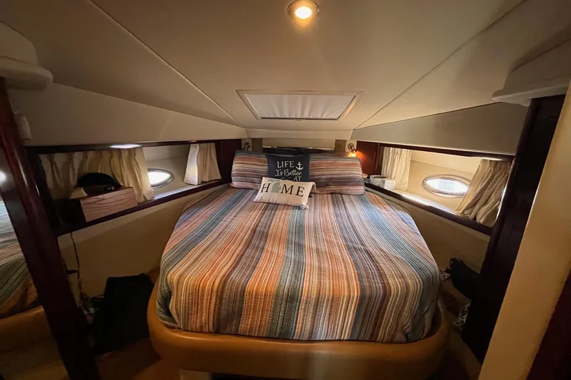 Sonship Yacht Photos Pics Cozy cabin interior of 2006 Sea Ray 380 Sundancer with striped bedding and decorative pillows.