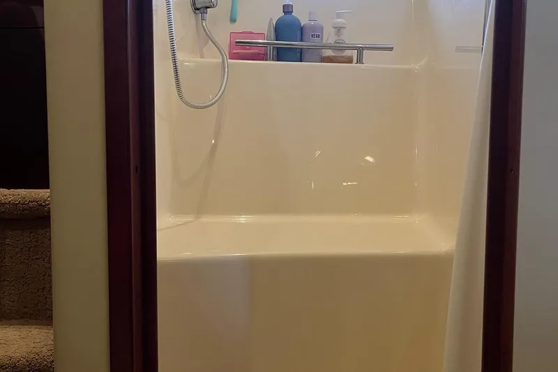 Sonship Yacht Photos Pics Shower area inside a 2006 Sea Ray 380 Sundancer yacht, featuring toiletries and a handheld showerhead.