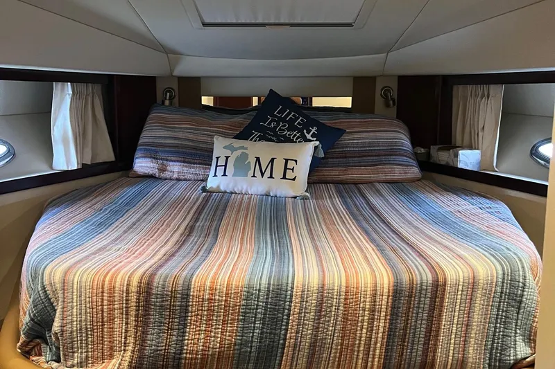 Sonship Yacht Photos Pics Cozy cabin interior of 2006 Sea Ray 380 Sundancer with striped bedding and decorative pillows.