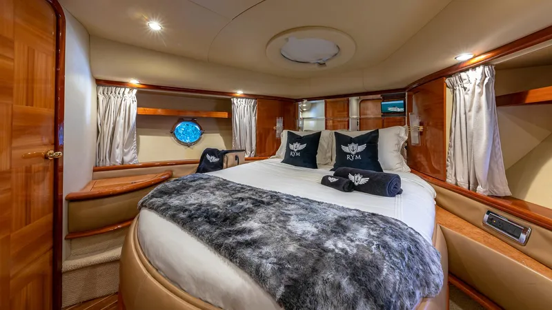  Yacht Photos Pics Luxurious bedroom interior of 2007 Azimut 62 Flybridge yacht with plush bedding and elegant wood finishes.