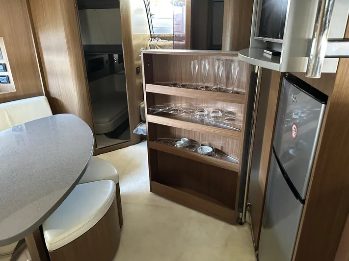  Yacht Photos Pics Interior of 2005 Riva 52 Rivale yacht with dining area and glassware cabinet.