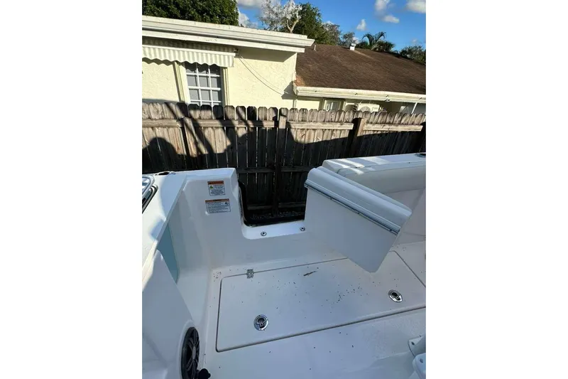  Yacht Photos Pics 2024 Sea Fox 268 Commander boat interior with seating and storage, near a wooden fence.