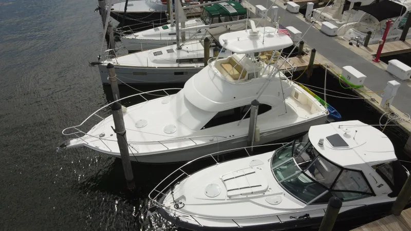  Yacht Photos Pics 2002 Riviera 37 Convertible yacht docked among other boats at a marina.