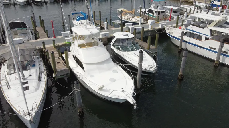  Yacht Photos Pics 2002 Riviera 37 Convertible yacht docked among other boats in a marina.