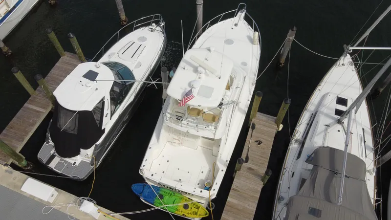  Yacht Photos Pics Aerial view of 2002 Riviera 37 Convertible yacht docked between two boats.