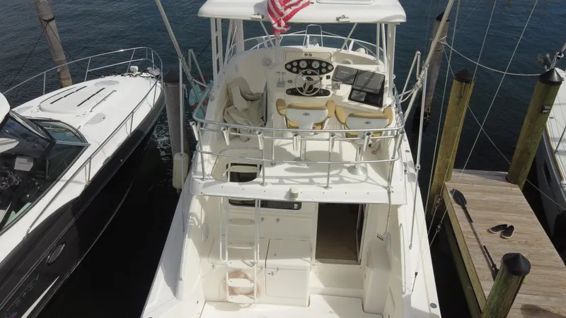  Yacht Photos Pics 2002 Riviera 37 Convertible yacht docked, featuring a spacious deck and helm with American flag.