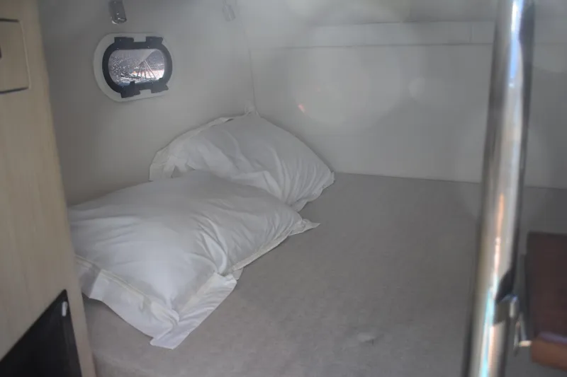  Yacht Photos Pics Cozy cabin interior of 2026 Regal 26 XO boat with pillows and porthole.