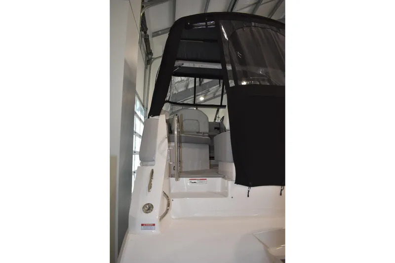  Yacht Photos Pics 2026 Regal 26 XO boat with black canopy in indoor storage.