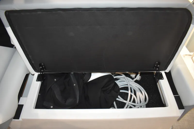  Yacht Photos Pics Open storage compartment on 2026 Regal 26 XO boat with coiled cables and fabric.