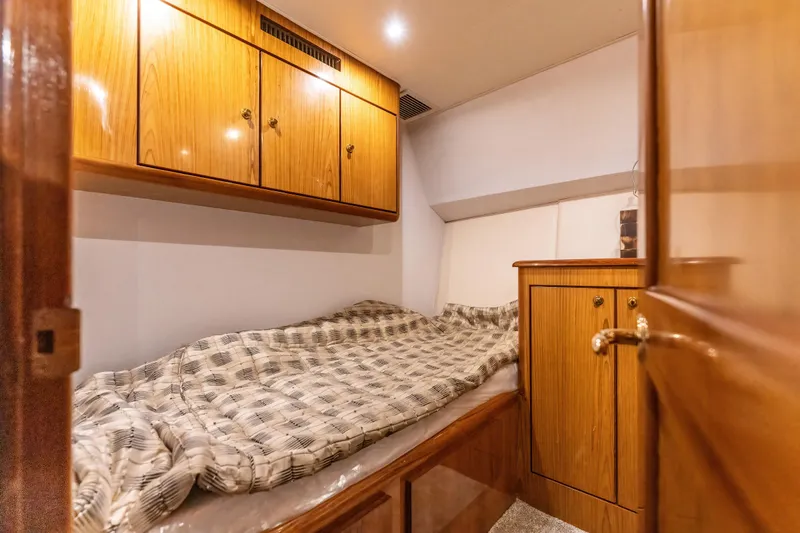  Yacht Photos Pics Cozy cabin interior of 2006 Ocean 57 yacht with wooden cabinets and bed.