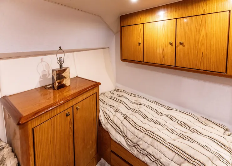  Yacht Photos Pics Cozy cabin interior of 2006 Ocean 57 yacht with wooden cabinets and single bed.