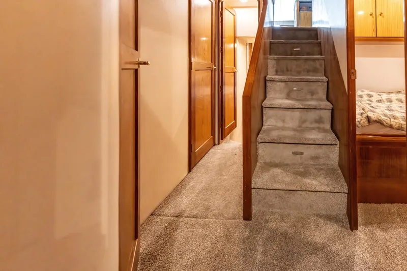  Yacht Photos Pics Interior of 2006 Ocean 57 yacht with carpeted stairs and wooden cabinetry.