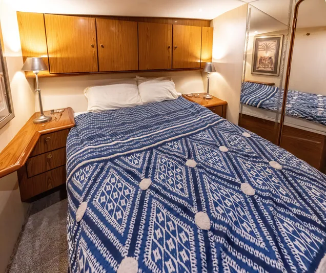  Yacht Photos Pics Cozy bedroom in 2006 Ocean 57 yacht with blue patterned bedding and wooden cabinets.