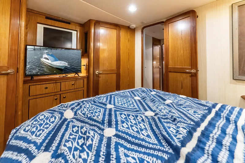  Yacht Photos Pics Luxurious 2006 Ocean 57 yacht bedroom with wooden cabinetry and patterned blue bedding.