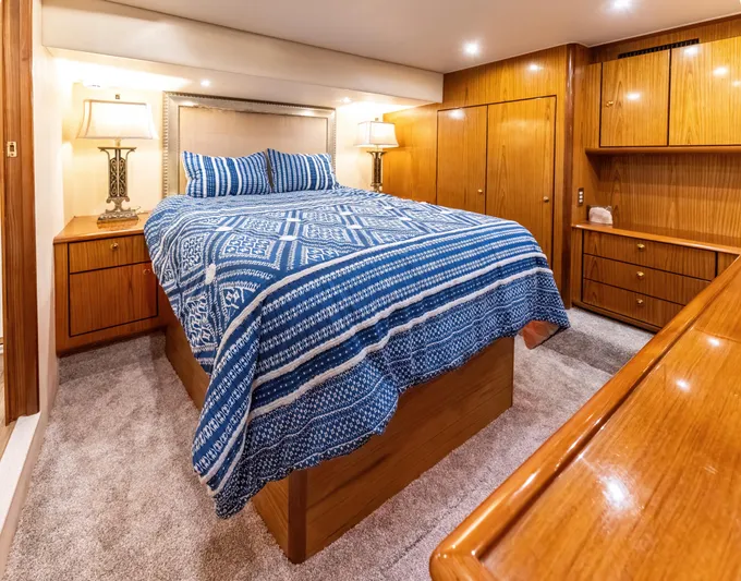  Yacht Photos Pics Luxurious bedroom in 2006 Ocean 57 yacht with blue bedding and wooden furnishings.