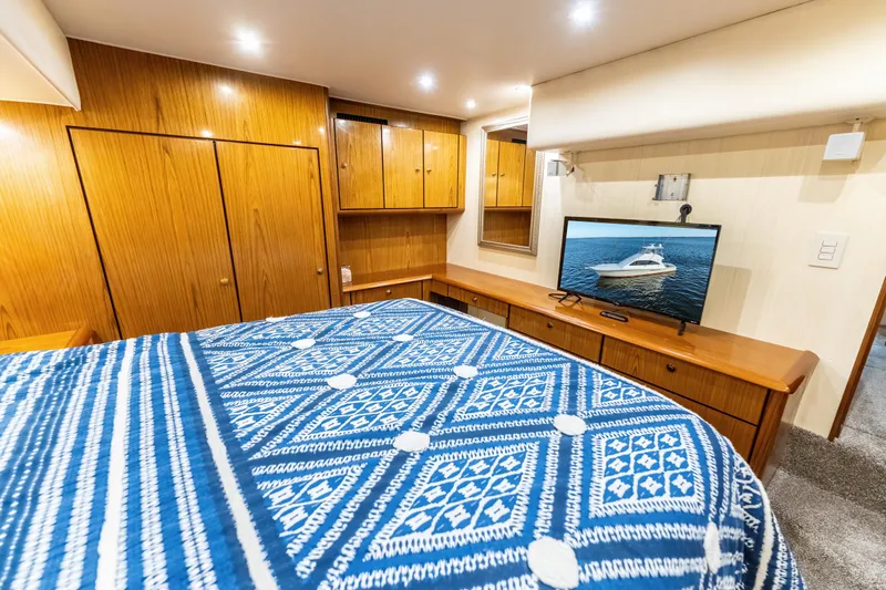  Yacht Photos Pics Luxurious 2006 Ocean 57 yacht bedroom with wood cabinetry and patterned bedding.