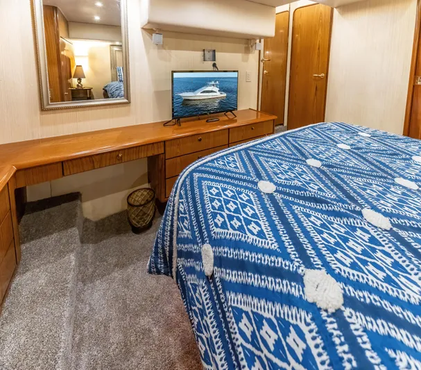  Yacht Photos Pics Luxurious Ocean 57 yacht bedroom interior, 2006 model, with blue patterned bedding and wooden furnishings.