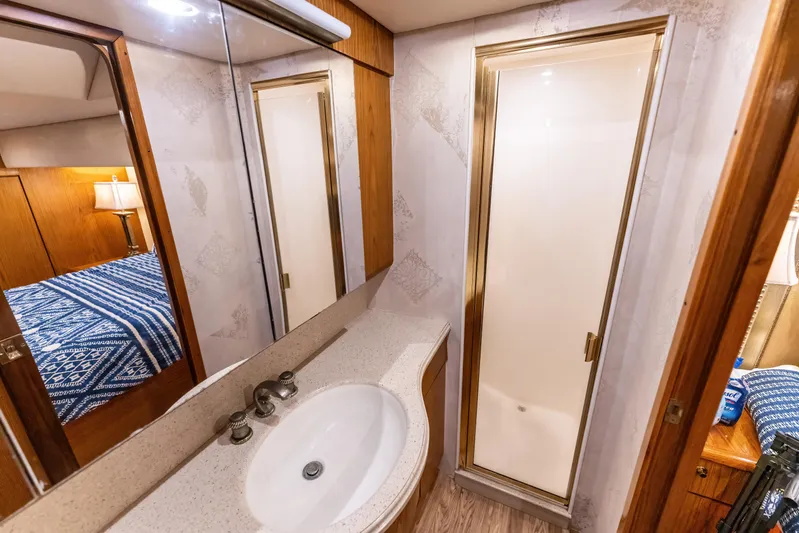  Yacht Photos Pics Luxurious 2006 Ocean 57 yacht bathroom with shower, sink, and mirrored cabinet.