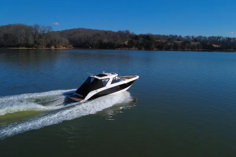  Yacht Photos Pics 2022 Sea Ray SLX 400 cruising on a serene lake under a clear blue sky.