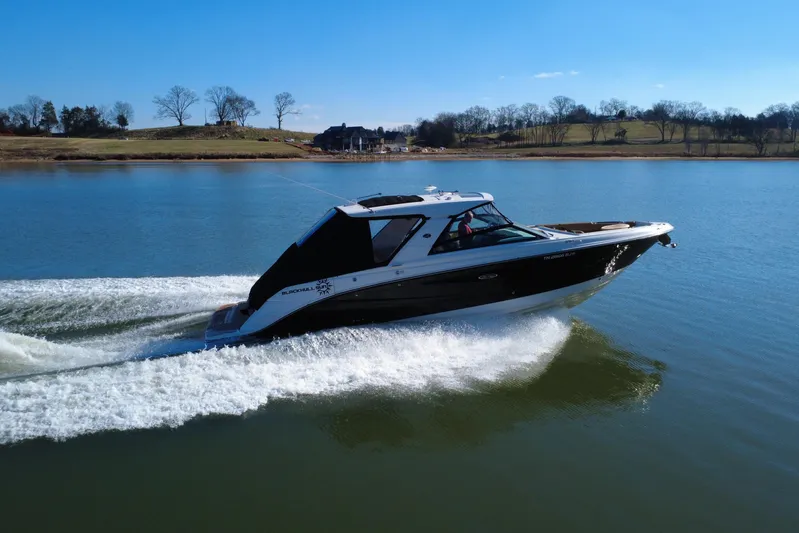  Yacht Photos Pics 2022 Sea Ray SLX 400 cruising on a serene lake under a clear blue sky.