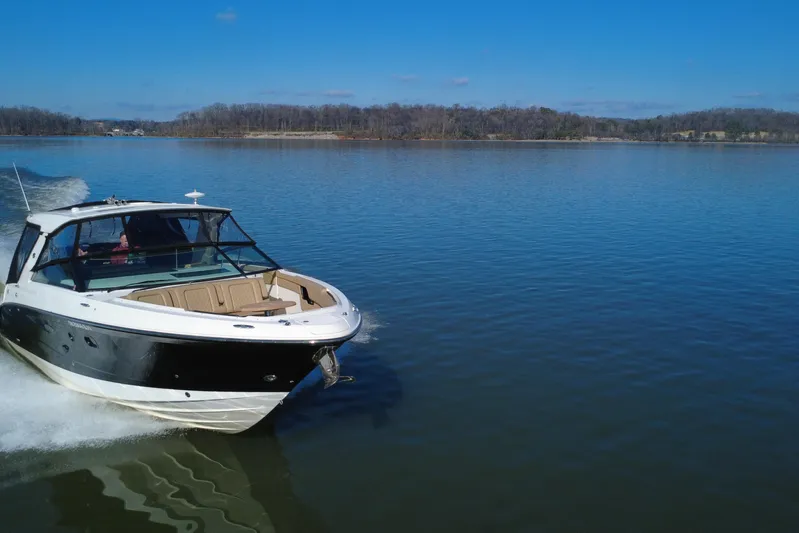  Yacht Photos Pics 2022 Sea Ray SLX 400 cruising on a calm lake under a clear blue sky.