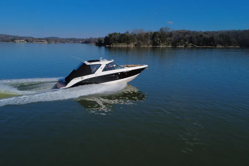 Yacht Photos Pics 2022 Sea Ray SLX 400 cruising on a serene lake under a clear blue sky.