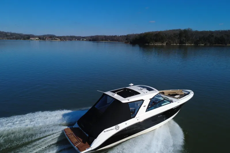 Yacht Photos Pics 2022 Sea Ray SLX 400 cruising on a serene lake under a clear blue sky.