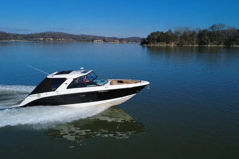  Yacht Photos Pics 2022 Sea Ray SLX 400 cruising on a serene lake under a clear blue sky.