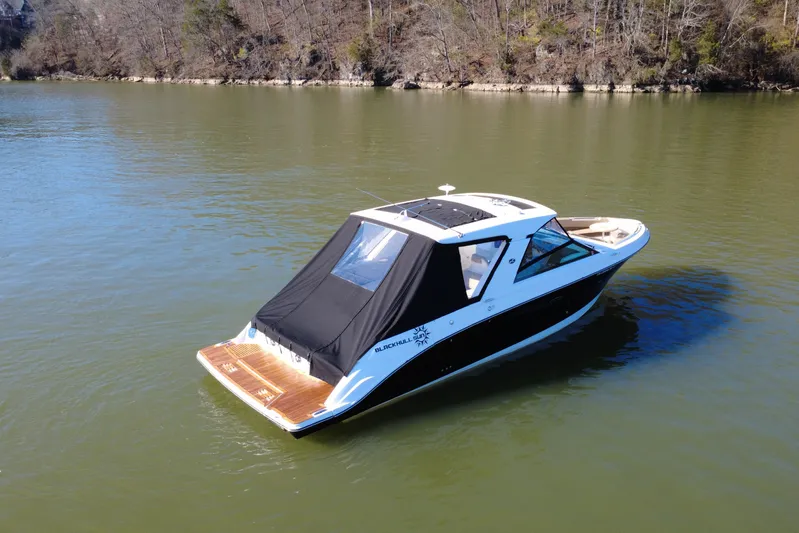  Yacht Photos Pics 2022 Sea Ray SLX 400 boat on calm lake with wooded shoreline.