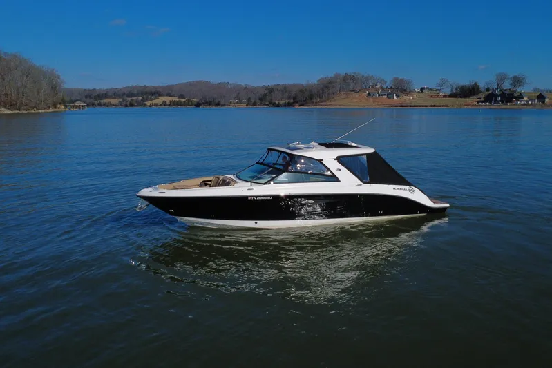  Yacht Photos Pics 2022 Sea Ray SLX 400 boat cruising on a serene lake under a clear blue sky.