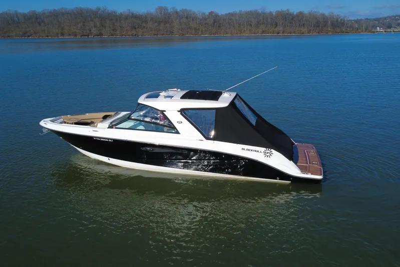  Yacht Photos Pics 2022 Sea Ray SLX 400 boat on calm lake with wooded shoreline.