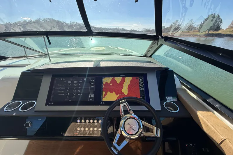  Yacht Photos Pics 2022 Sea Ray SLX 400 dashboard with navigation display and steering wheel on a sunny day.